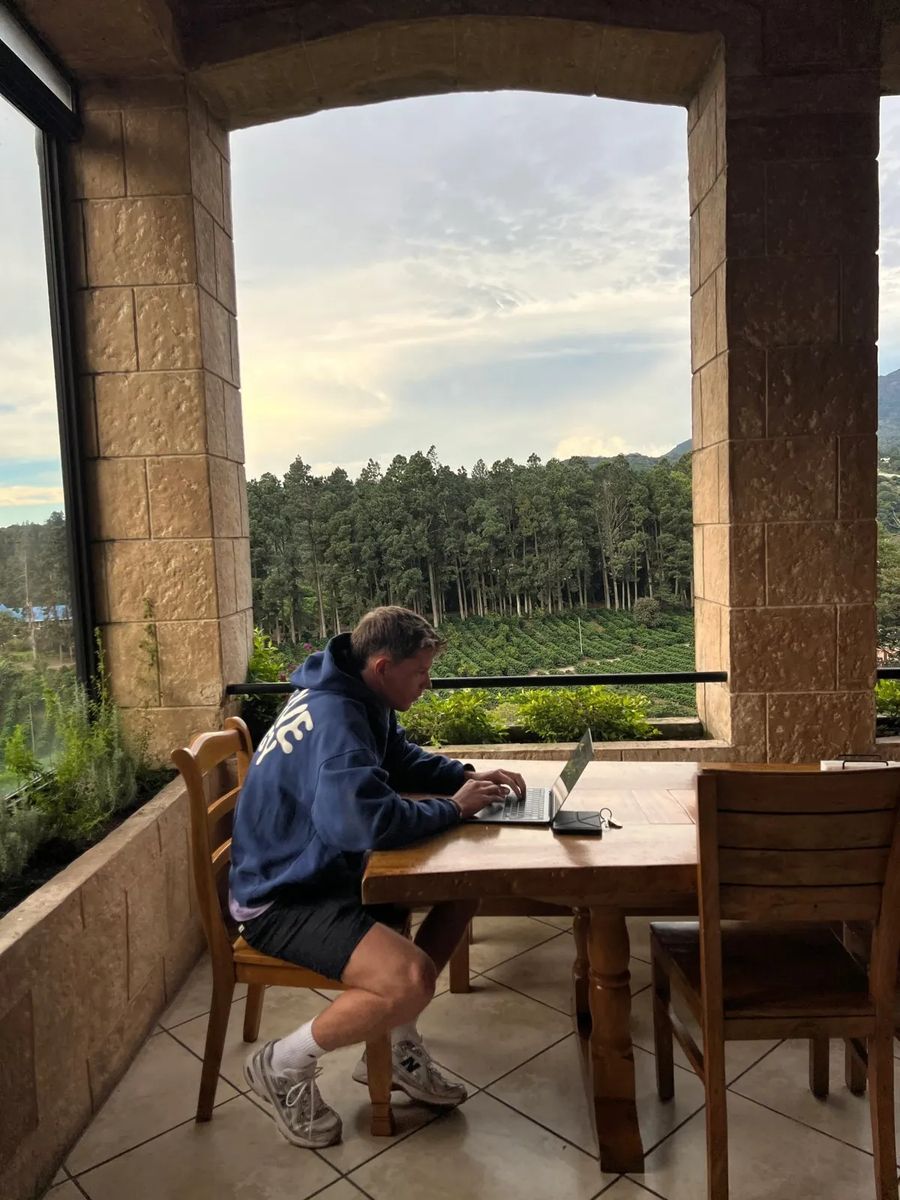 Martijn working on a laptop at a table overlooking a forest